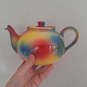 Ceramiczny czajniczek w stylu vintage z tęczową glazurą, wielokolorowy, czerwony, żółty, niebieski, zielony, okrągły, kolorowy, retro, kuchenny eksponat