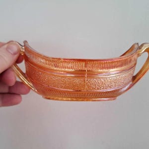 May include: A vintage amber glass serving dish with two handles. The dish has a textured surface and a ribbed design.