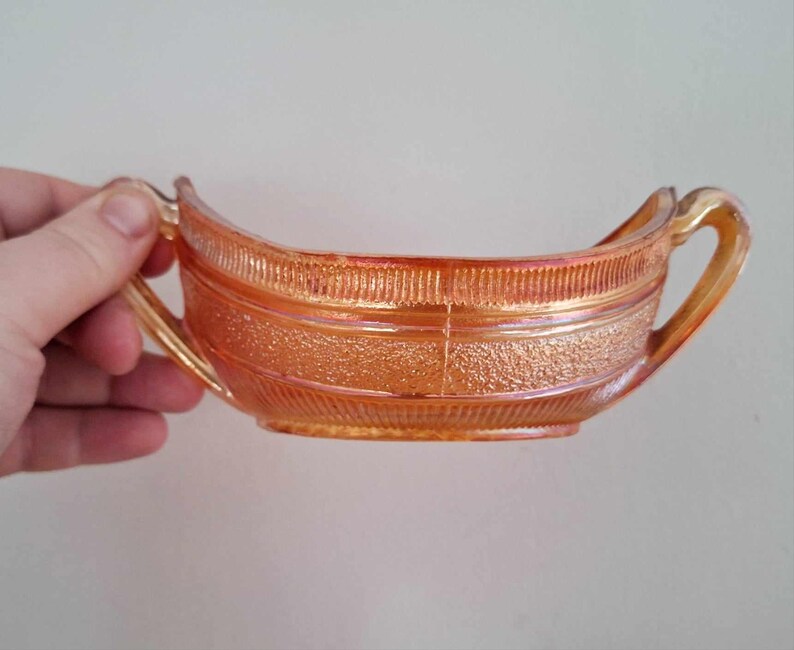 May include: A vintage amber glass serving dish with two handles. The dish has a textured surface and a ribbed design.