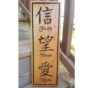 May include: A wooden sign with the Chinese characters for faith, hope, and love, along with the English translations below each character.