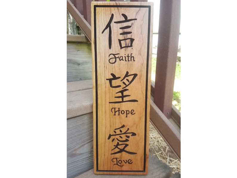 May include: A wooden sign with the Chinese characters for faith, hope, and love, along with the English translations below each character.