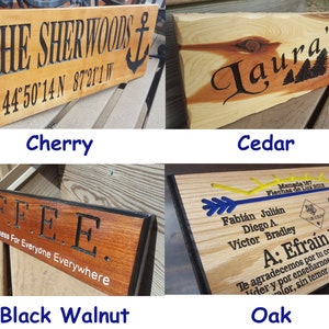 May include: Four wooden signs with different wood types and engraved text. The signs are labeled with the wood type: Cherry, Cedar, Black Walnut, and Oak. The text on the signs reads: "THE SHERWOONS 44 50 14 N 87 21 1 W", "Laura's", "COFFEE Dries Offers Forgiveness For Everyone Everywhere", and "Manada 187 Flechas de Luz 2018 Fabi&aacute;n Juli&aacute;n Diego A. Victor Bradley A: Efra&iacute;n Rosario Antonio Joel Diego J. Jean Norman Te agradecemos por tu compromiso, por ser l&iacute;der y por ense&ntilde;arnos que todo debe hacer valor, sin temor, pero siempre con".