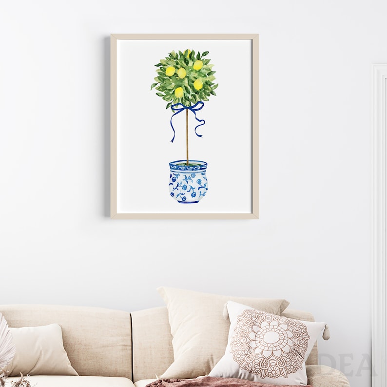 Pode incluir: Uma pintura em aquarela de uma &aacute;rvore de lim&atilde;o em um vaso de cer&acirc;mica azul e branco. A &aacute;rvore est&aacute; amarrada com uma fita azul e tem lim&otilde;es amarelos.