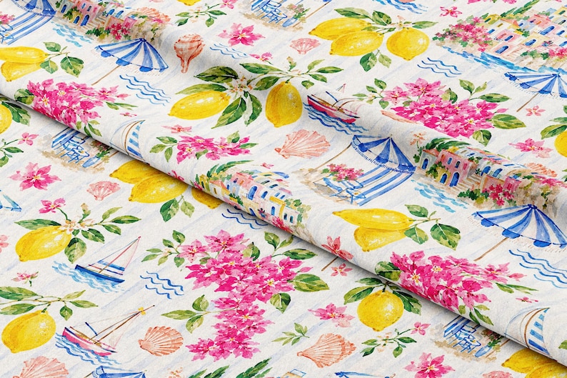 May include: White fabric with a watercolor design featuring yellow lemons, pink flowers, blue and white striped umbrellas, sailboats, and seashells. The pattern has a coastal theme.