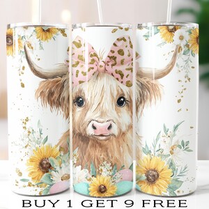 May include: Three white insulated tumblers with a watercolor design featuring a Highland cow with a pink bow and sunflowers. The tumblers have a straw and are decorated with floral accents and gold glitter. The text "BUY 1 GET 9 FREE" is at the bottom.
