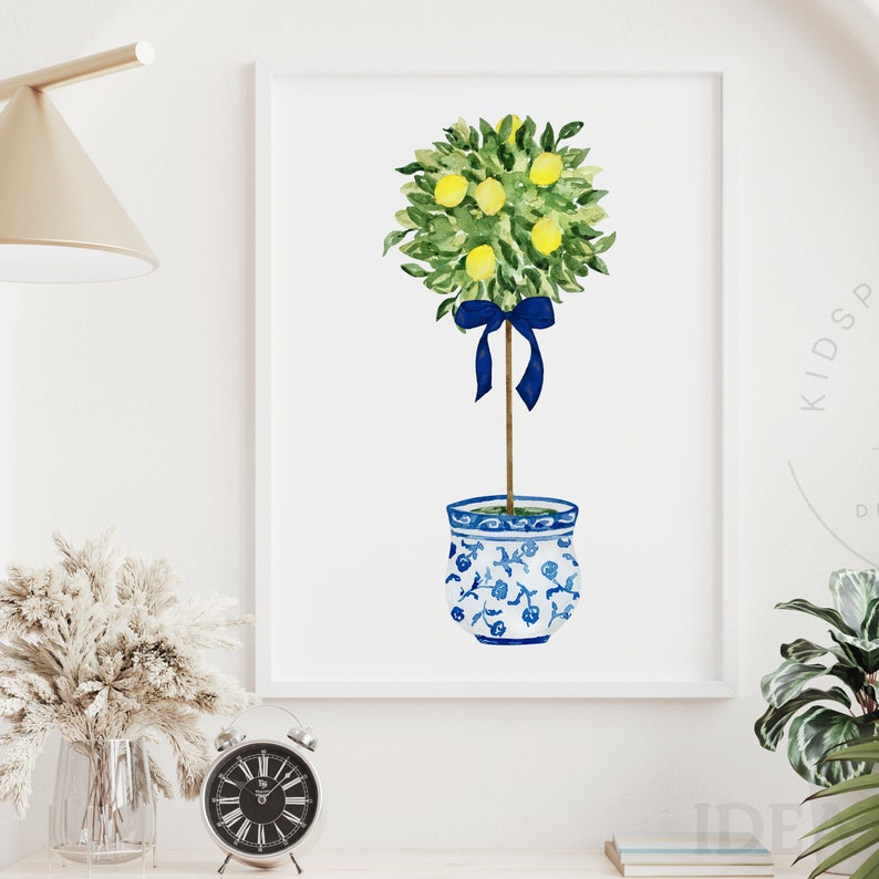 Pode incluir: Uma pintura em aquarela de uma &aacute;rvore de lim&atilde;o com uma fita azul amarrada ao redor do tronco. A &aacute;rvore est&aacute; plantada em um vaso de cer&acirc;mica azul e branco com um design floral.