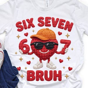 May include: White t-shirt with a red knitted heart wearing sunglasses and a brown cap. The numbers "6" and "7" are held by the heart, with the word "BRUH" below. Gold stars and red hearts are scattered around the design.