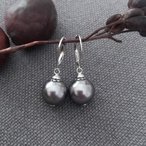 Svarta runda snäckskalspärlor i sterlingsilver med hävstångsbakgrund och dingelörhängen i träkolsvart E646SCP