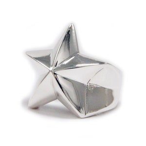 Puede incluir: Un anillo de plata con un gran diseño de estrella tridimensional.