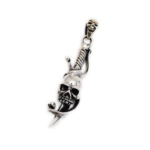 May include: Silver pendant featuring a skull with a dagger piercing through it. The dagger is twisted and has a skull at the top.