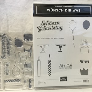 May include: Clear stamp set with images of birthday cake, candles, balloons, and the text "Schönen Geburtstag" and "Wünsch dir was".