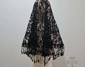 May include: A black lace veil with a floral pattern and a fringed edge. The veil is draped over a mannequin head, showcasing its design and texture. The delicate lace creates a semi-transparent effect.