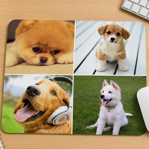 May include: A rectangular mouse pad featuring a four-panel collage of dogs. The top left shows a fluffy tan puppy, the top right a brown and white puppy, the bottom left a golden dog wearing headphones, and the bottom right a white puppy on grass.
