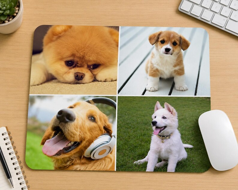 May include: A rectangular mouse pad featuring a four-panel collage of dogs. The top left shows a fluffy tan puppy, the top right a brown and white puppy, the bottom left a golden dog wearing headphones, and the bottom right a white puppy on grass.