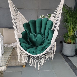 Peut inclure: Un fauteuil hamac en velours vert avec un coussin en forme de cœur. Le hamac est suspendu à une corde blanche et a une bordure en franges.