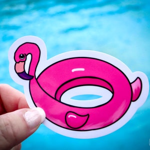 May include: Pink inflatable flamingo pool float sticker. The sticker is white with a pink flamingo shaped pool float. The flamingo has a black outline and a purple beak.