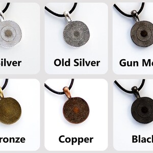 May include: Six round pendants with different finishes: silver, old silver, gun metal, bronze, copper, and black. Each pendant is on a black cord.