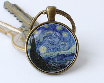 May include: A bronze key chain with a round glass charm featuring a reproduction of Vincent van Gogh's "Starry Night" painting.