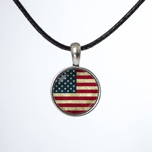 May include: A silver necklace with a round pendant featuring a vintage-style American flag design.