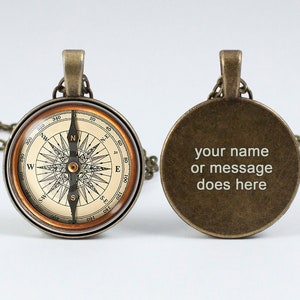 May include: Antique bronze compass pendant necklace. The front features a detailed compass rose design with directional markings. The back of the pendant has the text "your name or message does here". The necklace has a matching bronze chain.