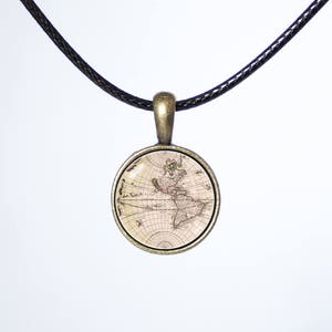 May include: A necklace with a black cord and a round pendant featuring an antique map of the world. The pendant is made of metal with a bronze finish.