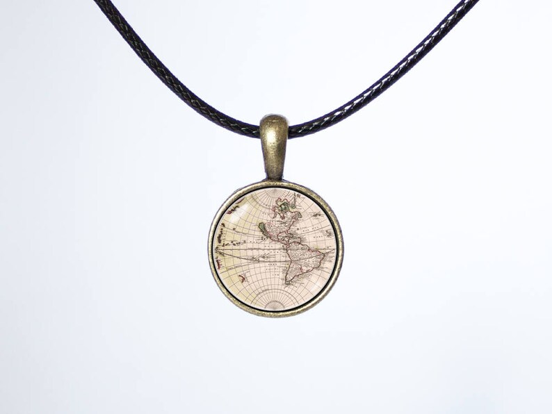 May include: A necklace with a black cord and a round pendant featuring an antique map of the world. The pendant is made of metal with a bronze finish.