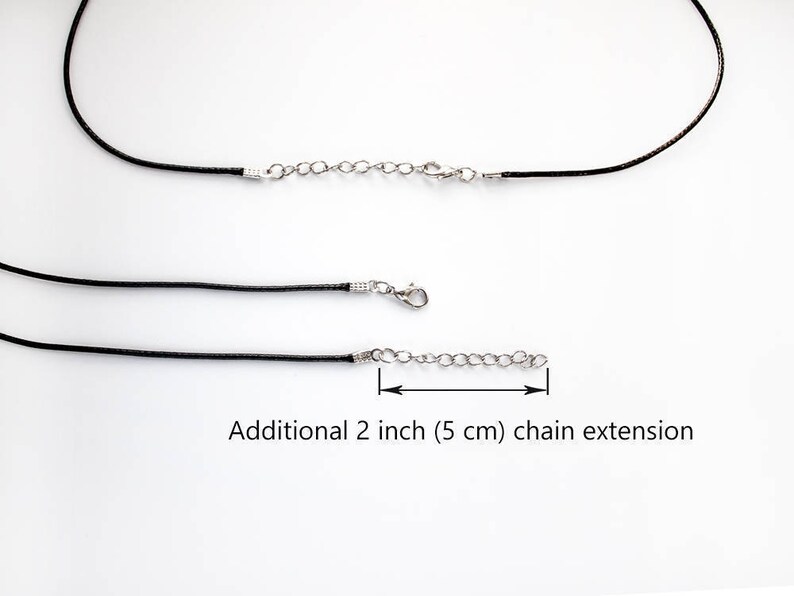 May include: Black cord necklace with a silver chain extension. The extension is 2 inches (5 cm) long. Additional 2 inch (5 cm) chain extension.
