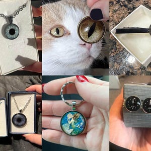 May include: A set of four different necklaces with eye-shaped pendants. The pendants are made of glass and have a black and white design. The necklaces are on display in small boxes.