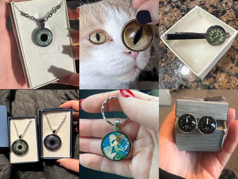 May include: A set of four different necklaces with eye-shaped pendants. The pendants are made of glass and have a black and white design. The necklaces are on display in small boxes.
