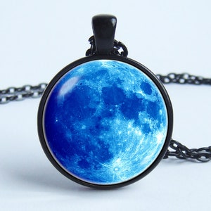 May include: A black chain necklace with a round pendant featuring a blue moon image.