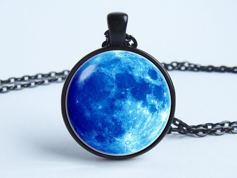 May include: A black chain necklace with a round pendant featuring a blue moon image.