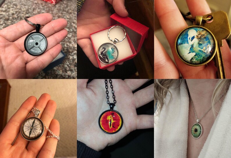 May include: A set of five different glass cabochon pendants with various designs. The pendants are on necklaces and keychains. The designs include a weight plate, a compass, a pair of swans, an eye, and a mermaid.