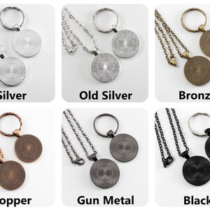 Puede incluir: Seis variaciones de color diferentes de un conjunto de collar y llavero. El conjunto incluye un collar y un llavero de plata, plata envejecida, bronce, cobre, metal de arma y negro. Cada conjunto presenta un colgante redondo con un dise&ntilde;o texturizado.