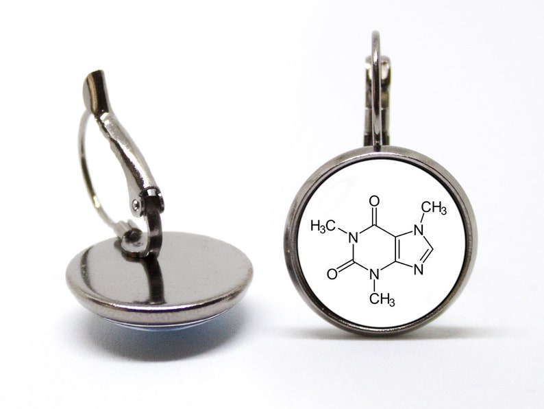 May include: Silver clip-on earrings with a white round charm featuring a black and white chemical structure diagram of caffeine.