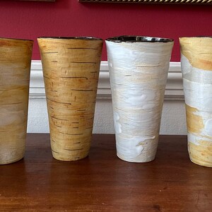 May include: Set of six ceramic vases with a birch bark pattern. The vases are white with brown accents and have a cylindrical shape.