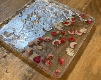 May include: A square clear resin coaster with a silver leaf design and pressed red and white flowers.