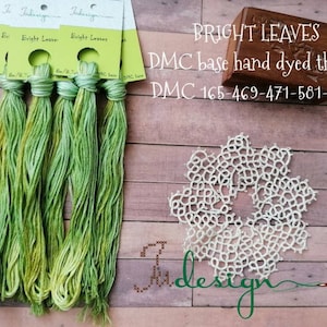 May include: Six skeins of hand-dyed DMC embroidery floss in shades of green. The floss is labelled "Bright Leaves" and the DMC base hand dyed thread is labelled "DMC 165-469-471-581-3819".