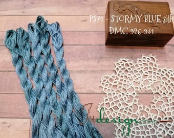 May include: A skein of blue embroidery floss with a wooden box labelled "PS71 - STORMY BLUE silk DMC 926-931".