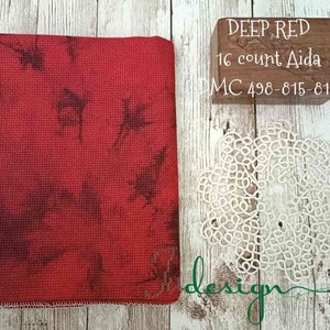 Peut inclure: Un morceau de tissu Aida 16 fils en rouge foncé. Le tissu est un tissu pour point de croix avec une légère texture. Le tissu est étiqueté "DEEP RED 16 count Aida DMC 498-815-816".