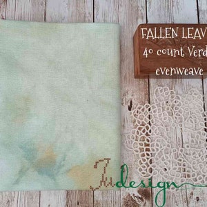 May include: A light green fabric with a subtle pattern, labeled "FALLEN LEAVES 40 count Verdal evenweave".