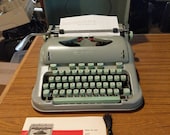 1963 Curvy Hermes 3000 portable typewriter with lid, manual, and cleaning brush
