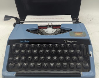 1980 blue Brother Charger 11 portable manual typewriter with carrying case - Spanish keyboard layout