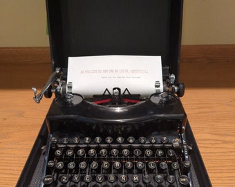 1940 glossy black Remington Rand Model 1 portable manual typewriter with case