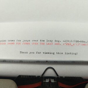 Pu&ograve; includere: Una macchina da scrivere con un foglio di carta inserito. La carta ha il testo "the quick brown fox jumps over the lazy dog. 234567890-%&cent;;/.. THE QUICK BROWN FOX JUMPS OVER THE LAZY DOG. +"#$%&'()*1%.." stampato su di essa. Il testo "Thank you for viewing this listing!" &egrave; anche stampato sulla carta.