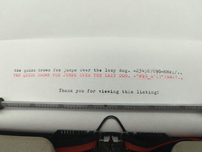 Pu&ograve; includere: Una macchina da scrivere con un foglio di carta inserito. La carta ha il testo "the quick brown fox jumps over the lazy dog. 234567890-%&cent;;/.. THE QUICK BROWN FOX JUMPS OVER THE LAZY DOG. +"#$%&'()*1%.." stampato su di essa. Il testo "Thank you for viewing this listing!" &egrave; anche stampato sulla carta.
