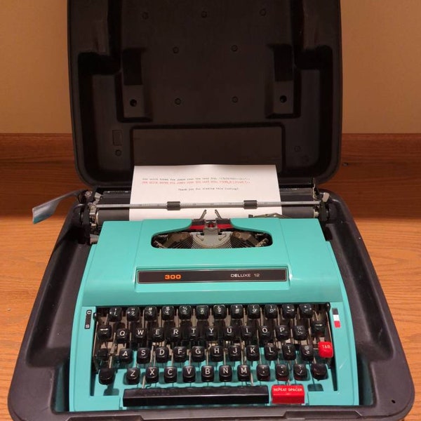 1977 Turquoise and black K-Mart 300 Deluxe 12 portable manual typewriter with carrying case