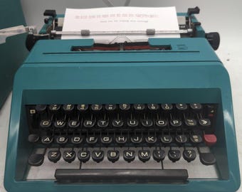 1969 teal Olivetti Studio 45 portable typewriter with owner's manual, case, and key