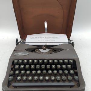1955 gray Hermes Rocket ultra portable manual typewriter with carrying case