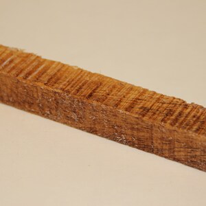 May include: A close-up of a brown wooden block with a rough, textured surface.