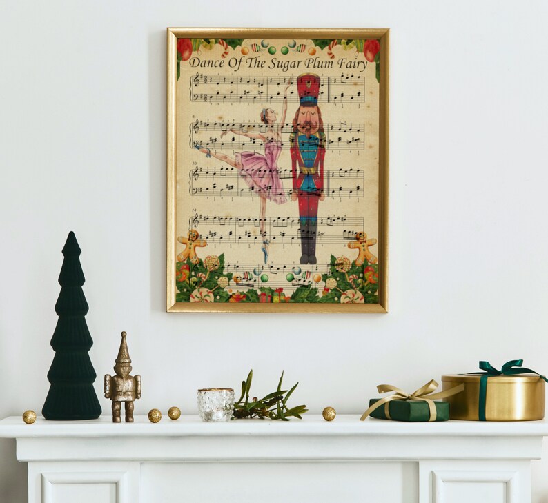 May include: A framed print of sheet music titled "Dance Of The Sugar Plum Fairy" featuring a ballerina and a nutcracker. The print is in a gold frame and is decorated with Christmas ornaments. A green Christmas tree and other holiday decorations are on the mantel.